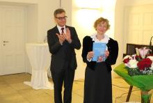 Mitherausgeber Thomas Prügl überreicht Marianne Schlosser die Festschrift.